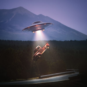 Unidentified flying object lifting a car from road. Concept of alien abduction. Clipping path included.